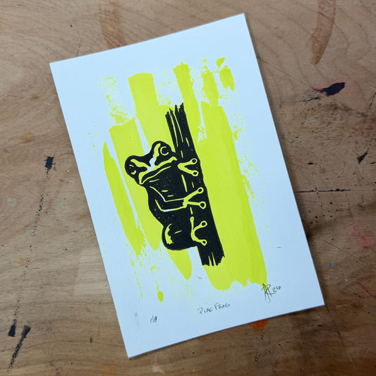 Pine Barrens Treefrog hand-pulled linocut in black over a fluorescent yellow-green painted background.