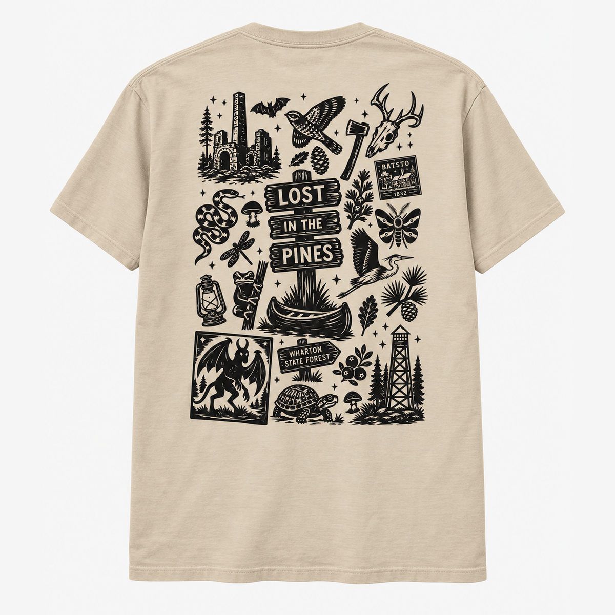 A beige short-sleeve t-shirt shown from the back, featuring a large black graphic print with various outdoor and rustic illustrations including a campfire, axe, snakes, a lighthouse, and the text 'LOST IN THE PINES'.